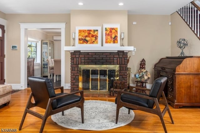 living area featuring wood finished floors, a fireplace, recessed lighting, and stairway
