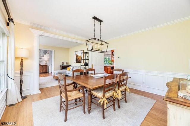 11 Brookside Dr, Peapack Gladstone Boro, NJ 07934 - dining area with light wood-type flooring, crown molding, wainscoting, decorative columns, and a chandelier