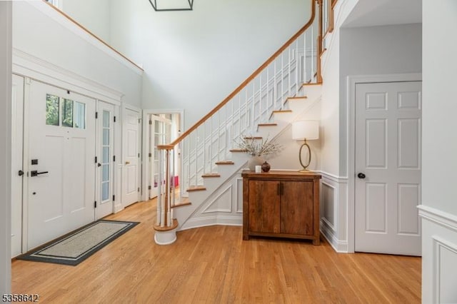 11 Brookside Dr, Peapack Gladstone Boro, NJ 07934 - entrance foyer with light wood-style flooring, stairs, a high ceiling, and a decorative wall