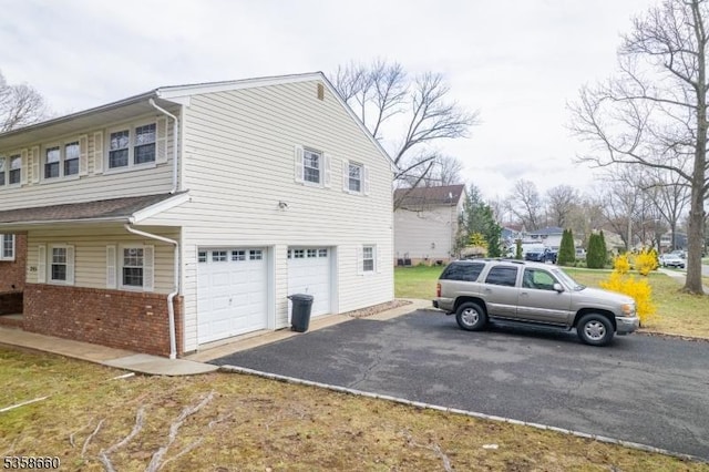 293 Oak Ridge Rd, Clark Twp, NJ 07066 - view of side of home with an attached garage, asphalt driveway, and brick siding