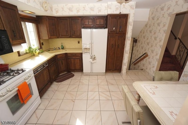293 Oak Ridge Rd, Clark Twp, NJ 07066 - kitchen featuring white appliances, wallpapered walls, a sink, light countertops, and light tile patterned flooring