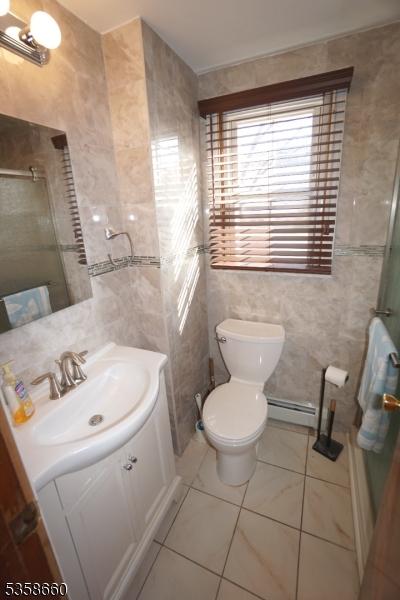 293 Oak Ridge Rd, Clark Twp, NJ 07066 - bathroom with tile walls, toilet, a shower, vanity, and tile patterned floors