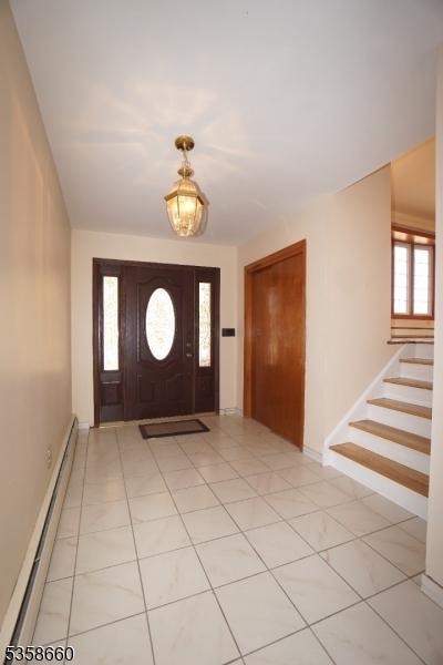 293 Oak Ridge Rd, Clark Twp, NJ 07066 - foyer entrance with a baseboard radiator, stairway, and baseboards