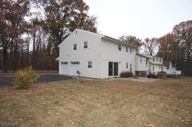 293 Oak Ridge Rd, Clark Twp, NJ 07066 - rear view of house featuring driveway, an attached garage, central AC, and a lawn
