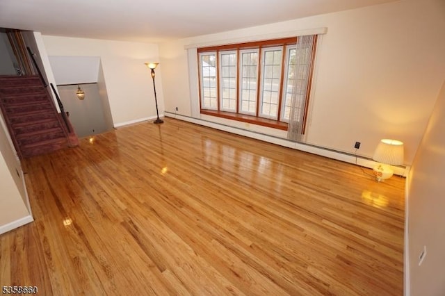 293 Oak Ridge Rd, Clark Twp, NJ 07066 - unfurnished living room featuring wood finished floors, a baseboard radiator, stairs, and baseboards