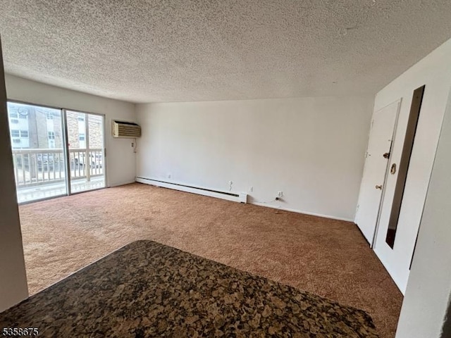 carpeted spare room with baseboard heating, a wall unit AC, and a textured ceiling