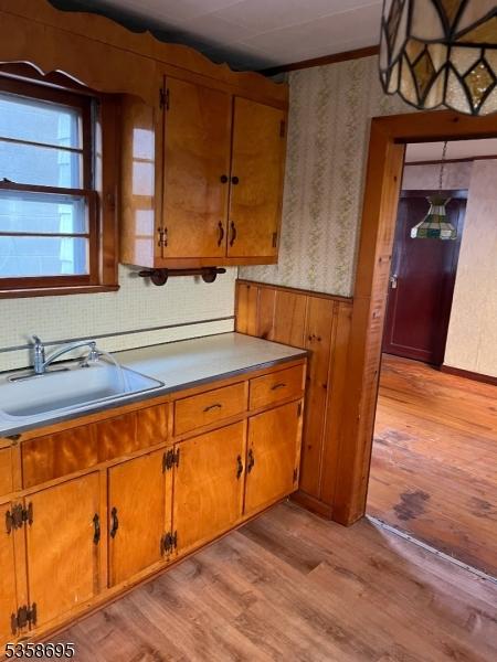 626 Tremont Ave, City Of Orange Twp, NJ 07050 - kitchen featuring a sink, wallpapered walls, light wood-style floors, and brown cabinetry