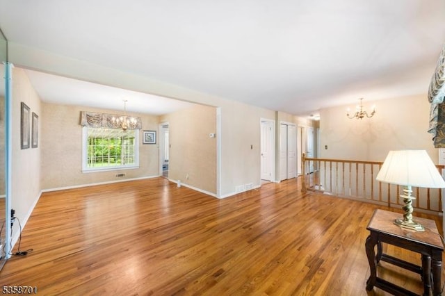 72 Brookside Dr, New Providence Boro, NJ 07974 - unfurnished living room featuring a chandelier, wood finished floors, and baseboards