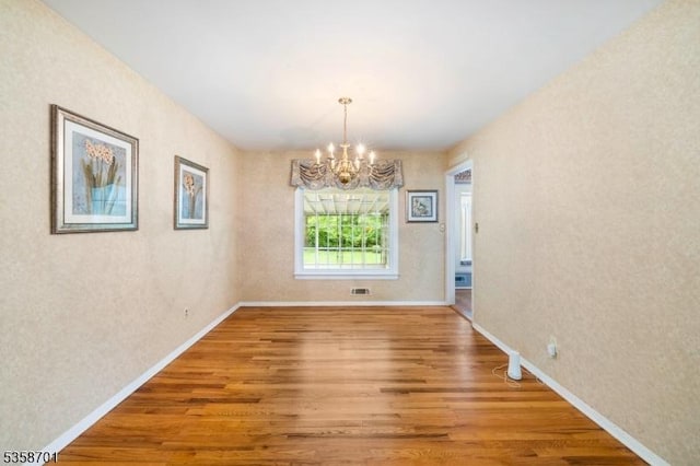 72 Brookside Dr, New Providence Boro, NJ 07974 - unfurnished dining area with a chandelier, wood finished floors, and baseboards