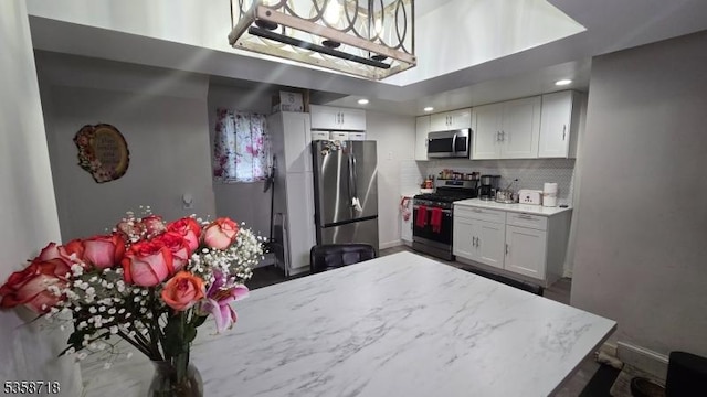 131-133 Sumner Ave, Plainfield City, NJ 07062 - kitchen with stainless steel appliances, decorative backsplash, white cabinetry, a high ceiling, and light stone countertops