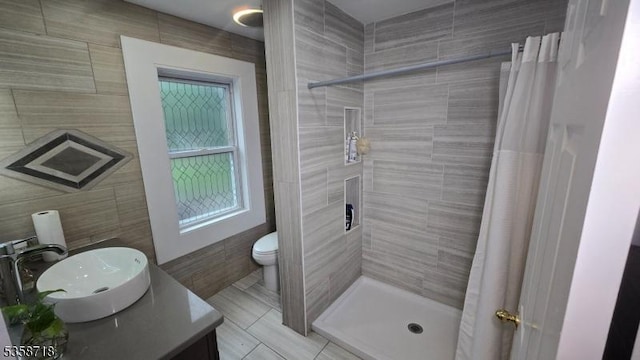 131-133 Sumner Ave, Plainfield City, NJ 07062 - full bathroom with tile walls, a shower stall, vanity, toilet, and tile patterned flooring