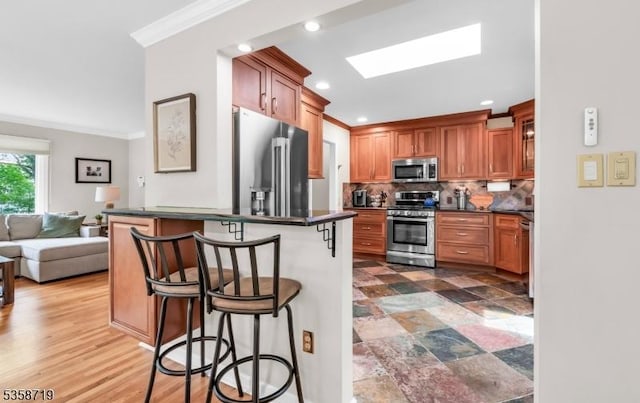 4-A Southview Rd, Randolph Twp, NJ 07869 - kitchen featuring appliances with stainless steel finishes, crown molding, dark countertops, a kitchen breakfast bar, and decorative backsplash