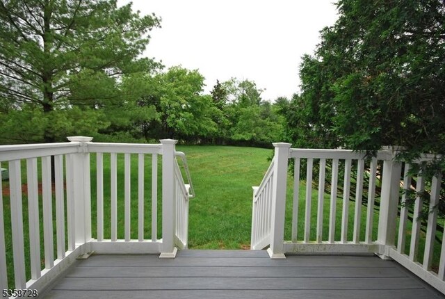 wooden terrace featuring a yard