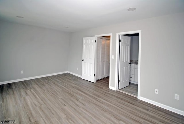 unfurnished bedroom with wood finished floors and baseboards