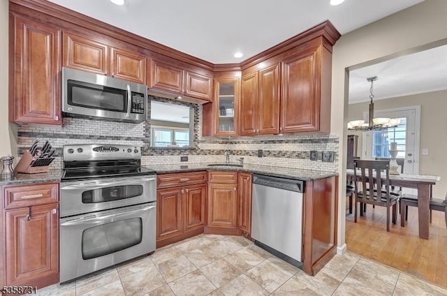 206 Thomas St, Cranford Twp, NJ 07016 - kitchen featuring appliances with stainless steel finishes, a sink, a chandelier, dark stone countertops, and brown cabinets