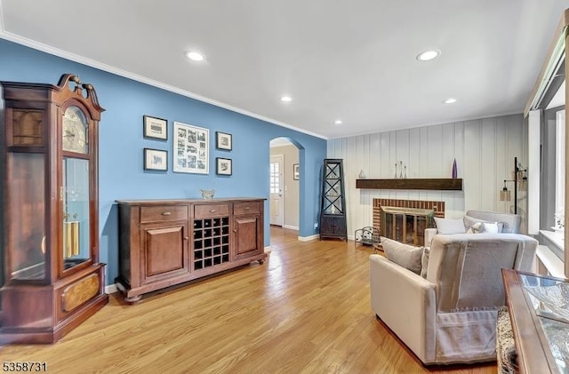 206 Thomas St, Cranford Twp, NJ 07016 - living room featuring ornamental molding, arched walkways, light wood-style flooring, a brick fireplace, and baseboards