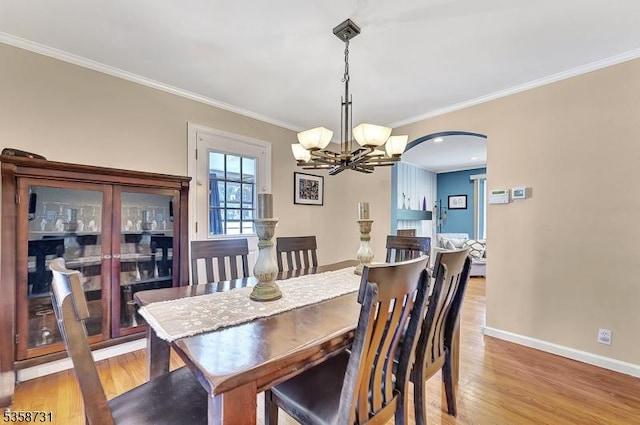 206 Thomas St, Cranford Twp, NJ 07016 - dining area with a chandelier, wood finished floors, crown molding, baseboards, and arched walkways
