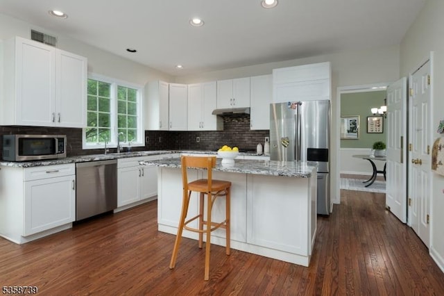 3 Firestone Ct, Montgomery Twp, NJ 08558 - kitchen with stainless steel appliances, a center island, under cabinet range hood, white cabinets, and a sink