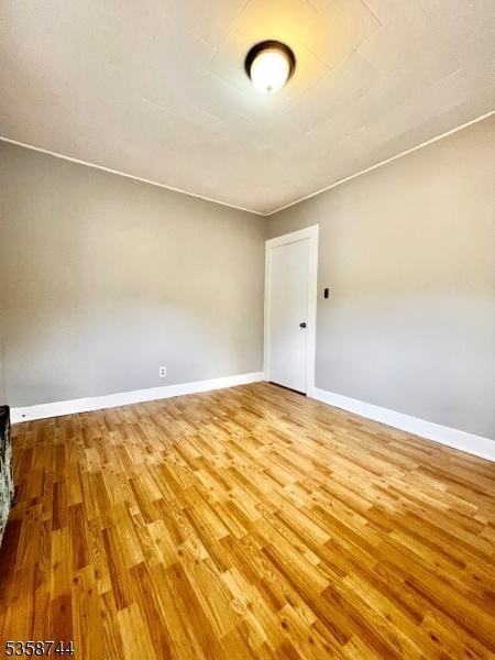 empty room featuring wood finished floors and baseboards