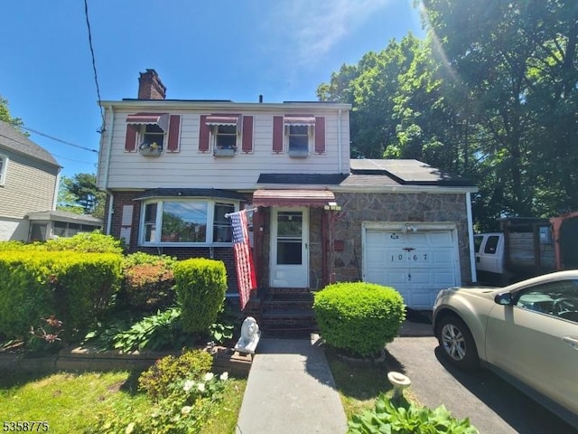 1067 Julia St, Teaneck Twp, NJ 07666 - view of front facade with a garage, a chimney, driveway, and brick siding
