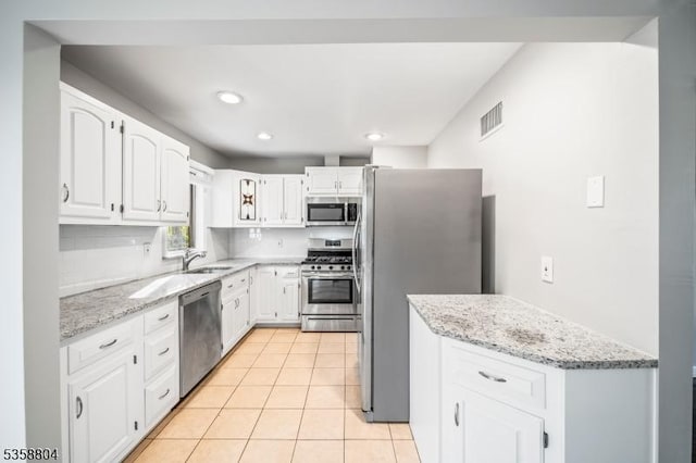 132 Hiawatha Blvd, Oakland Boro, NJ 07436 - kitchen featuring appliances with stainless steel finishes, a sink, white cabinetry, light stone counters, and recessed lighting