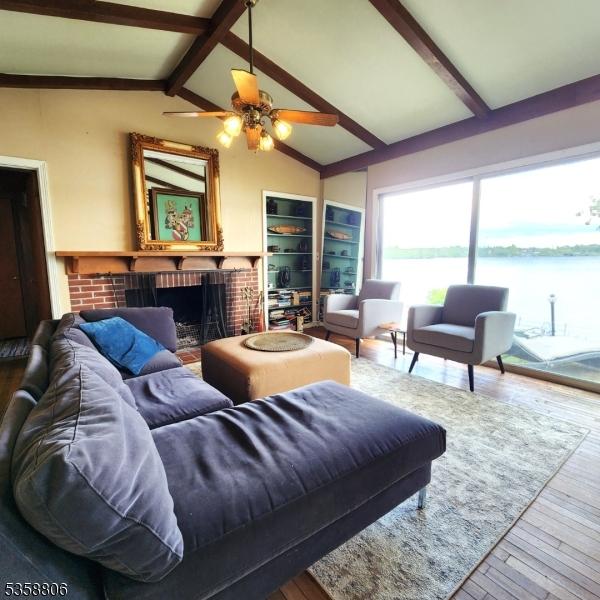 110 Lower N Shore Rd, Frankford Twp, NJ 07826 - living area featuring hardwood / wood-style floors, a fireplace, a water view, and a ceiling fan