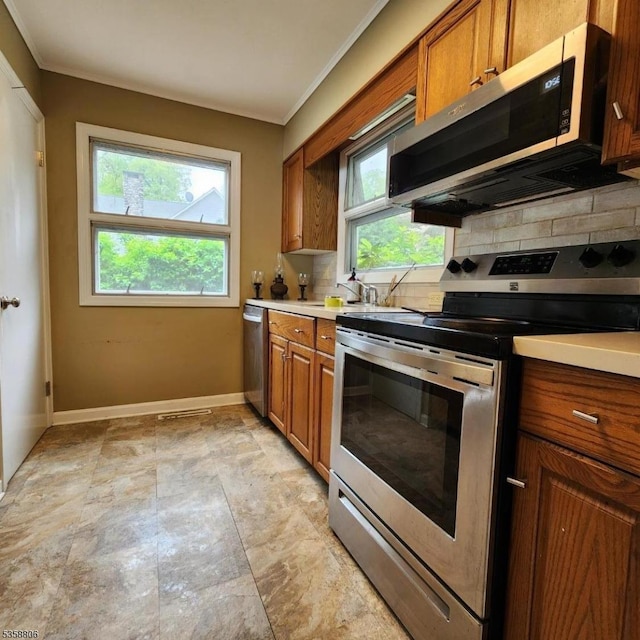 110 Lower N Shore Rd, Frankford Twp, NJ 07826 - kitchen with stainless steel appliances, decorative backsplash, brown cabinetry, crown molding, and baseboards