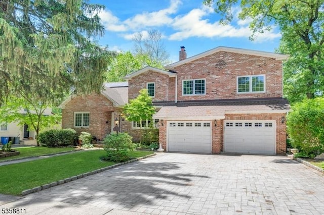 21-23 Sheridan Ave, West Orange Twp, NJ 07052 - traditional home featuring a garage, decorative driveway, a front yard, a chimney, and brick siding