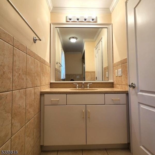 15 Hemlock Ave, Frankford Twp, NJ 07826 - bathroom with ornamental molding, tile walls, vanity, tile patterned flooring, and wainscoting