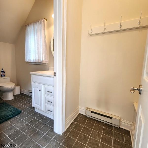15 Hemlock Ave, Frankford Twp, NJ 07826 - bathroom featuring baseboard heating, vaulted ceiling, toilet, tile patterned floors, and vanity