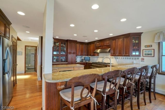 599 Point Ave, Brick Twp, NJ 08724 - kitchen with stainless steel refrigerator with ice dispenser, ventilation hood, a peninsula, tasteful backsplash, and light wood finished floors