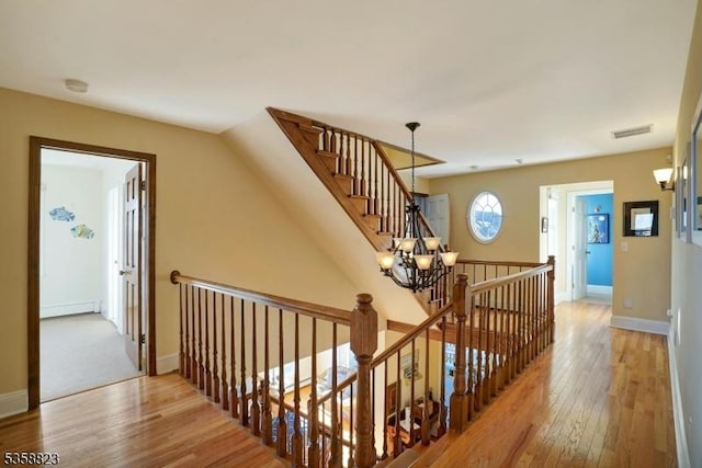 599 Point Ave, Brick Twp, NJ 08724 - stairs featuring a chandelier, wood-type flooring, baseboards, and a baseboard radiator
