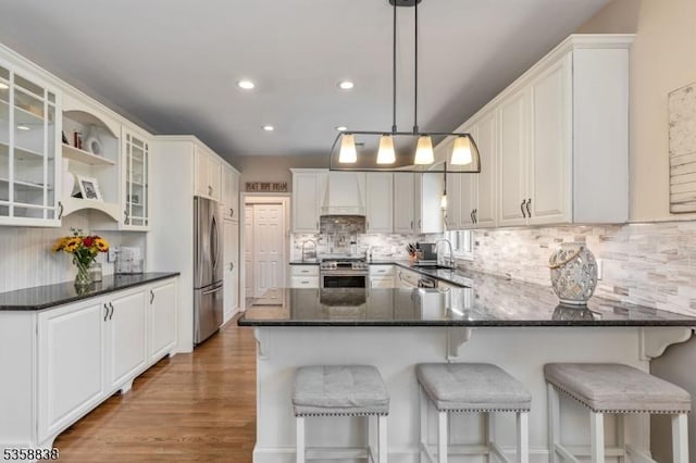 411 Arlington Ave, South Plainfield Boro, NJ 07080 - kitchen featuring appliances with stainless steel finishes, a peninsula, tasteful backsplash, a sink, and glass insert cabinets