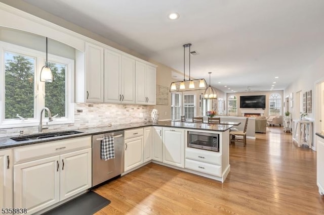 411 Arlington Ave, South Plainfield Boro, NJ 07080 - kitchen with appliances with stainless steel finishes, a sink, a peninsula, light wood-style floors, and backsplash