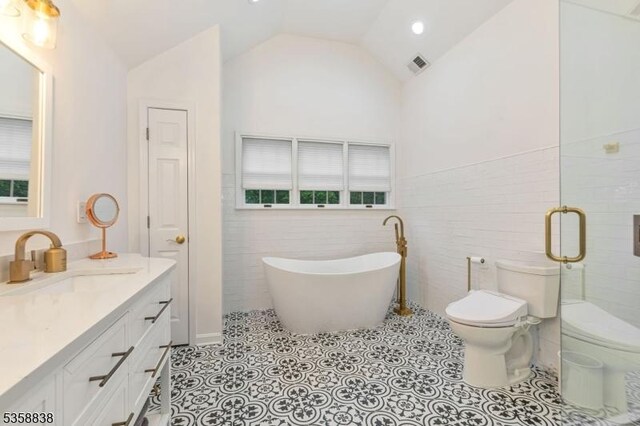 411 Arlington Ave, South Plainfield Boro, NJ 07080 - bathroom with toilet, a freestanding tub, vanity, lofted ceiling, and tile walls
