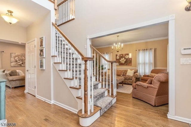 411 Arlington Ave, South Plainfield Boro, NJ 07080 - staircase featuring wood finished floors, crown molding, a chandelier, baseboards, and a towering ceiling