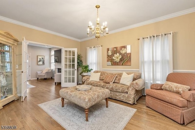 411 Arlington Ave, South Plainfield Boro, NJ 07080 - living area with french doors, a chandelier, crown molding, plenty of natural light, and light wood-style floors