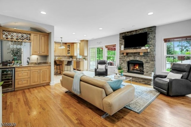 1364 Springfield Ave, New Providence Boro, NJ 07974 - living area featuring wine cooler, bar with sink, light wood finished floors, recessed lighting, and a stone fireplace