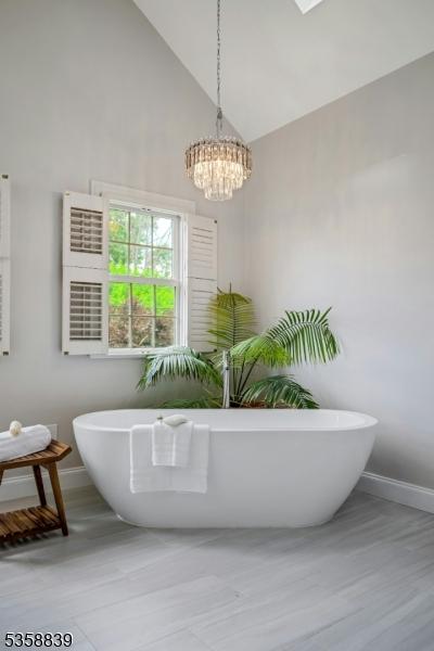 1364 Springfield Ave, New Providence Boro, NJ 07974 - bathroom featuring a freestanding tub, high vaulted ceiling, and a chandelier