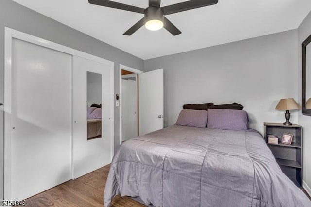 bedroom with wood finished floors, ceiling fan, and a closet