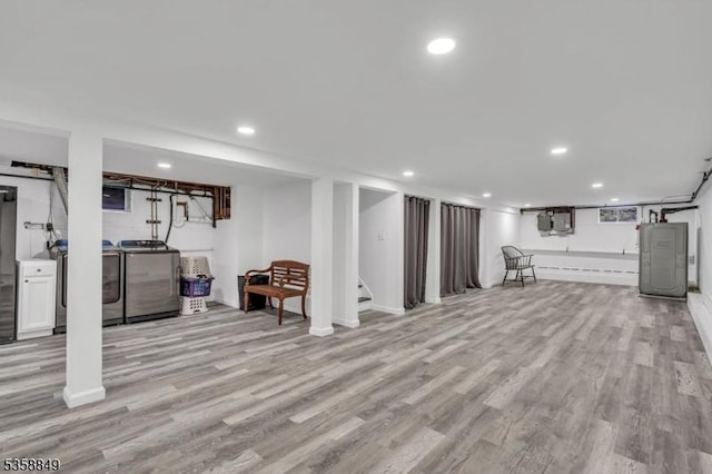 finished basement featuring separate washer and dryer, light wood-style flooring, recessed lighting, stairway, and baseboards