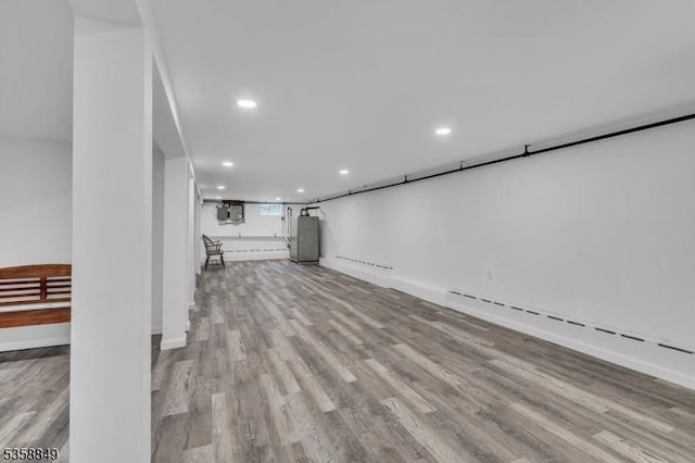 unfurnished living room featuring wood finished floors, recessed lighting, and baseboards