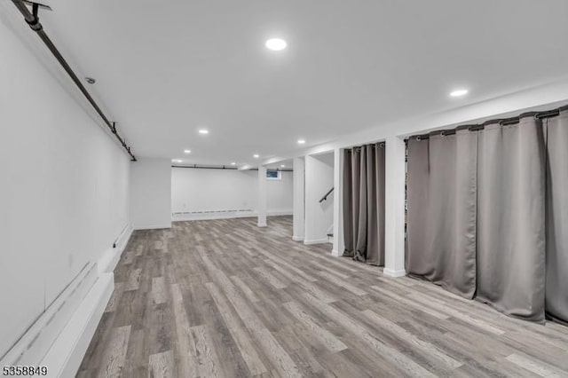 finished basement featuring recessed lighting, wood finished floors, stairway, and baseboards