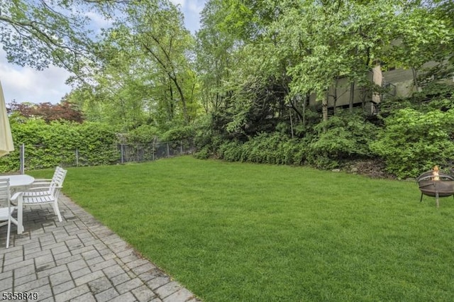 view of yard with an outdoor fire pit and a patio