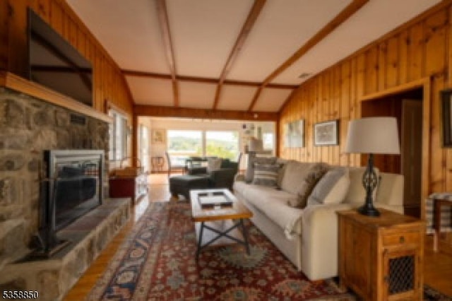 120 Island Rd, Vernon Twp, NJ 07422 - living room with a glass covered fireplace, wood walls, and lofted ceiling