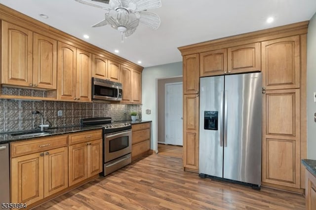 44 Stanhope Rd, Sparta Twp, NJ 07871 - kitchen featuring appliances with stainless steel finishes, a sink, decorative backsplash, ceiling fan, and light wood-style flooring