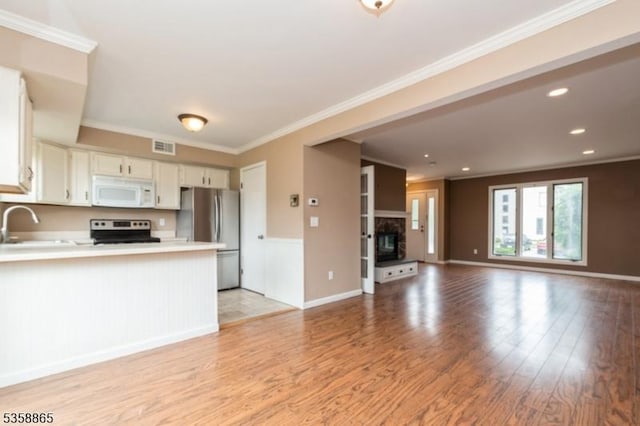 182 Dakota Dr, Andover Twp, NJ 07848 - kitchen featuring appliances with stainless steel finishes, open floor plan, light wood-style floors, white cabinets, and a peninsula
