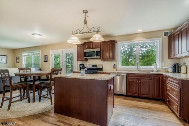 221 Sussex Ave, Andover Twp, NJ 07860 - kitchen featuring appliances with stainless steel finishes, light wood-style flooring, a sink, a kitchen island, and light stone counters