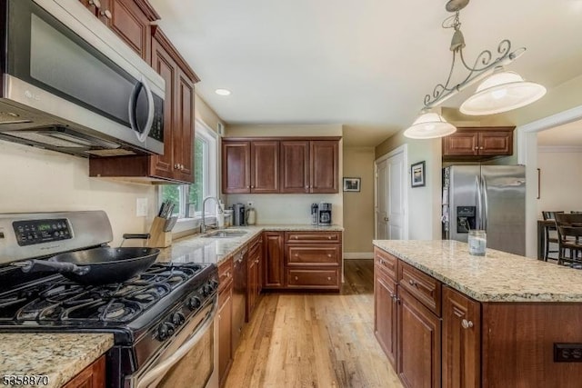 221 Sussex Ave, Andover Twp, NJ 07860 - kitchen featuring appliances with stainless steel finishes, a sink, light wood finished floors, light stone countertops, and a center island