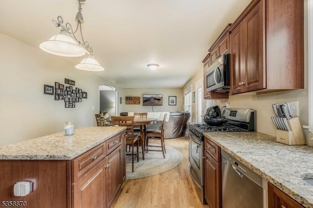 221 Sussex Ave, Andover Twp, NJ 07860 - kitchen with stainless steel appliances, light wood-style flooring, brown cabinets, and arched walkways